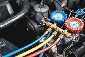a/c recharge, auto repair in Belton, MO at Belton Transmission & Complete Auto Repair. Image of manifold gauges connected to a car’s air conditioning system.