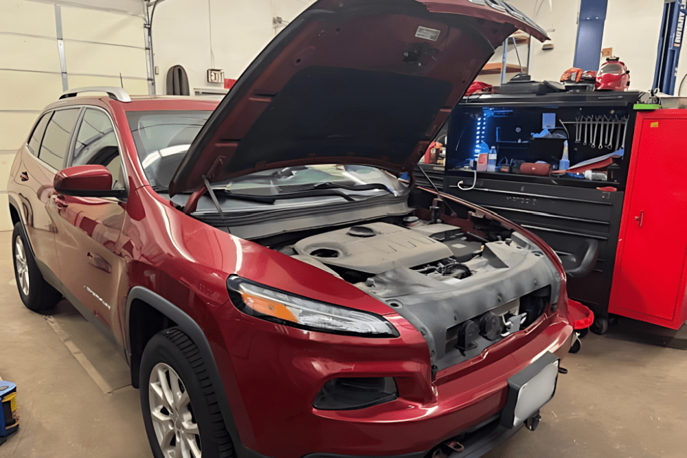 Car maintenance in Belton, MO by Belton Transmission & Complete Auto Repair. Image of a red Cherokee in the shop with the hood open, highlighting professional diagnostics and repair services to keep vehicles running smoothly.