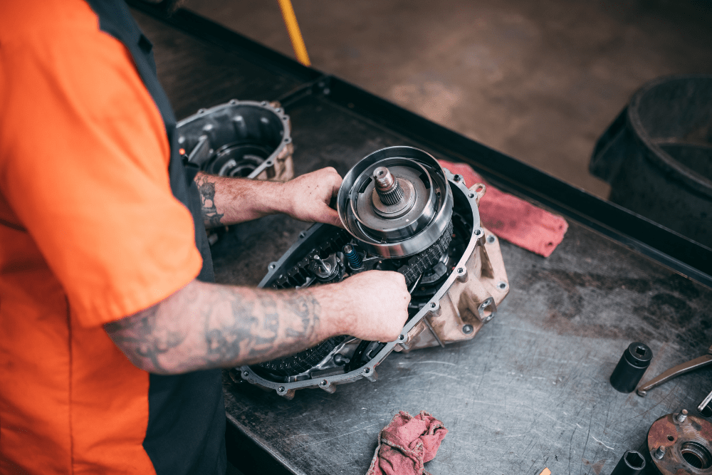 Transmission repair in Belton, MO by Belton Transmission & Complete Auto Repair. Image showing a technician working on a disassembled transmission, emphasizing precision repair and rebuild services to keep vehicles running smoothly.