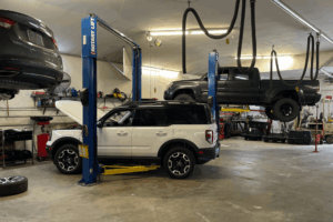 Car inspection, auto repair in Belton, MO by Belton Transmission & Complete Auto Repair. Image of multiple vehicles on lifts inside the shop during a comprehensive vehicle inspection, emphasizing thorough diagnostics, preventative care, and a commitment to safety and reliability.