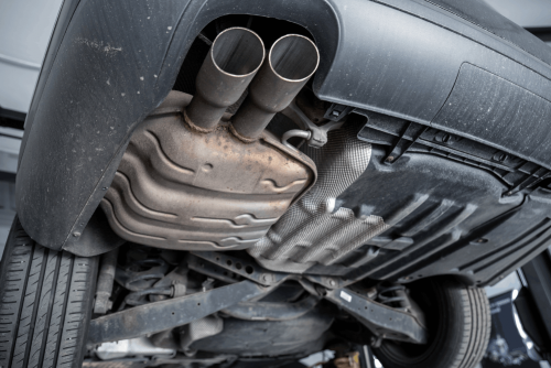 Exhaust repair and muffler service in Belton, MO at Belton Transmission & Complete Auto Repair. Image of vehicle exhaust system and muffler underneath the car during professional exhaust inspection and repair to improve performance and reduce noise.